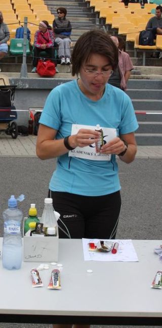 žena v modrém tričku u stolu s občerstvením